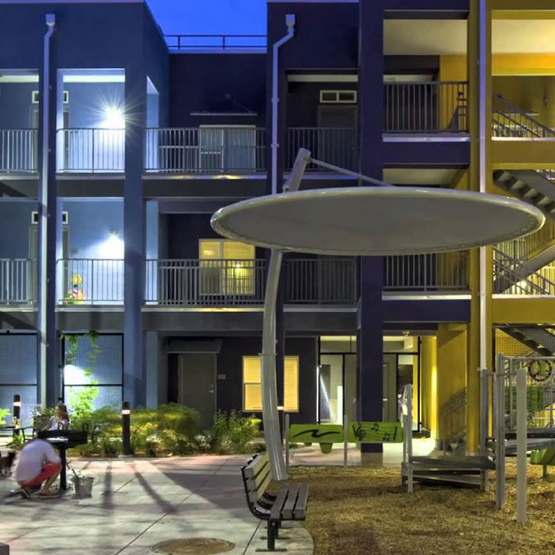 A street scene of an apartment complex at night.