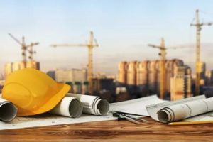 A construction site with a yellow hard hat and some papers.