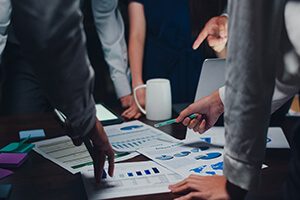 A group of people standing around a table with papers.